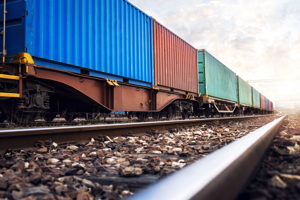 train-wagons-carrying-cargo-containers-shipping-companies a large long train on a steel track