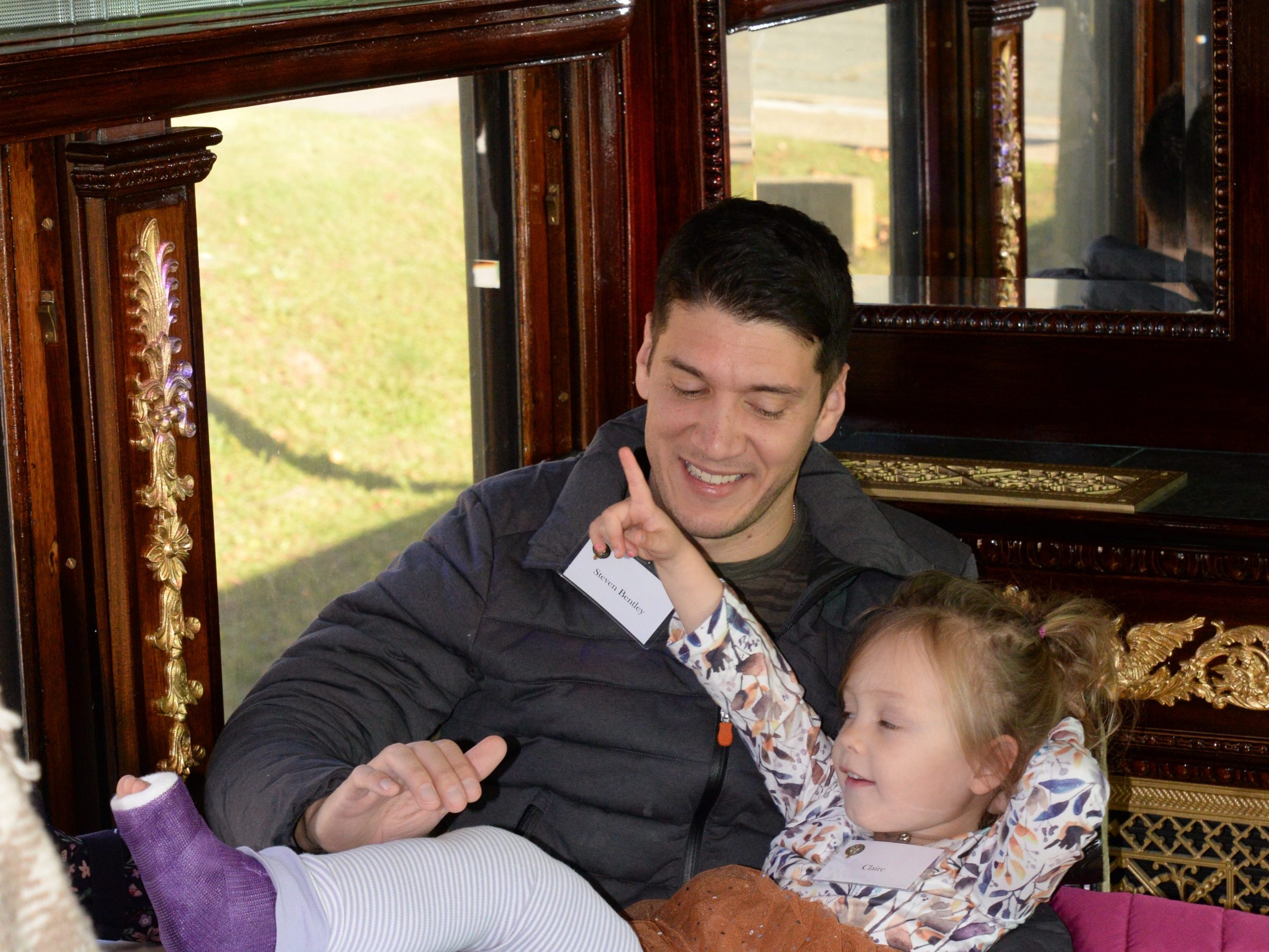 a person holding a teddy bear sitting next to a window
