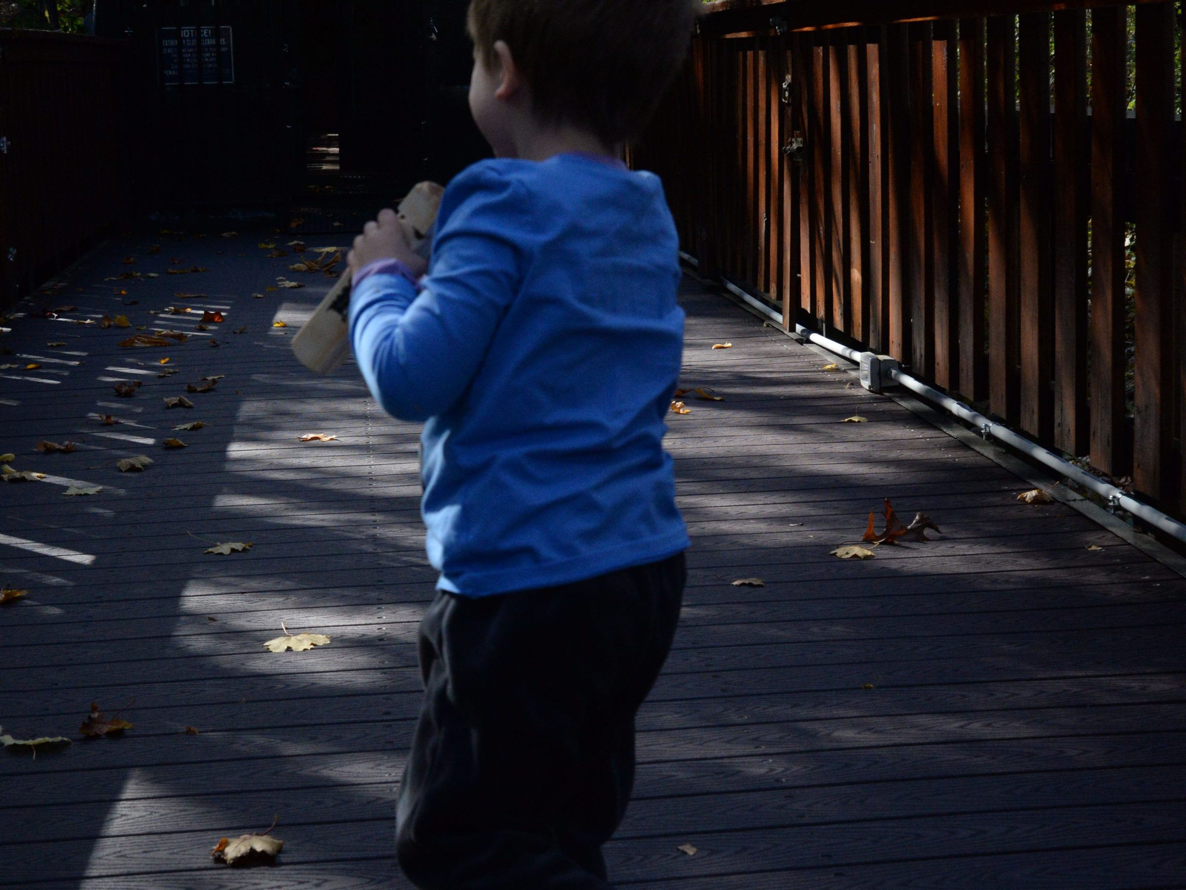 a young boy riding a skateboard down a sidewalk