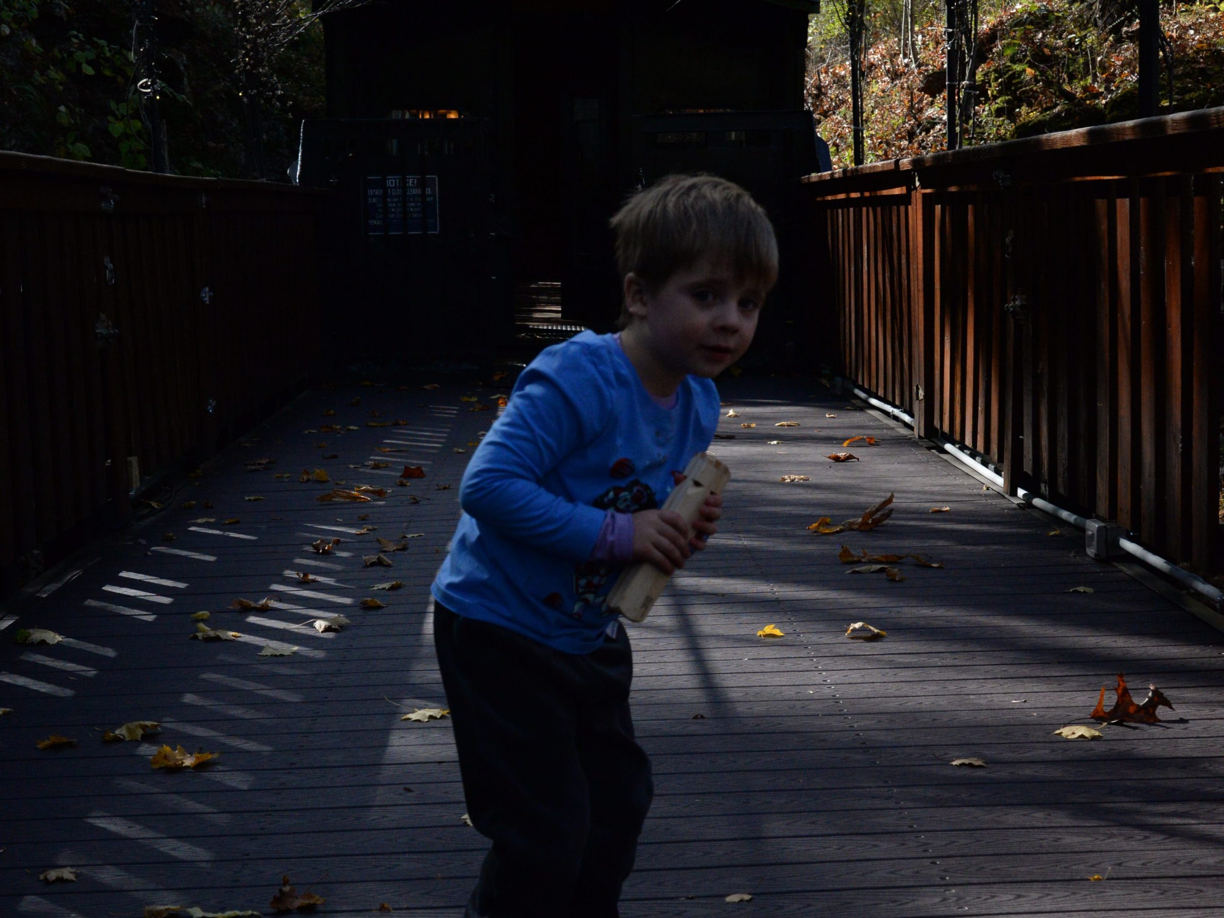 a young boy riding a skateboard down a sidewalk