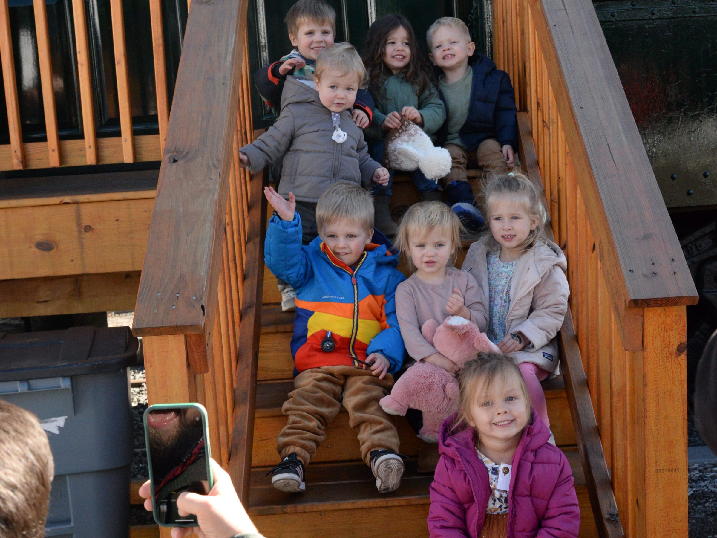 a group of people sitting around a wooden fence