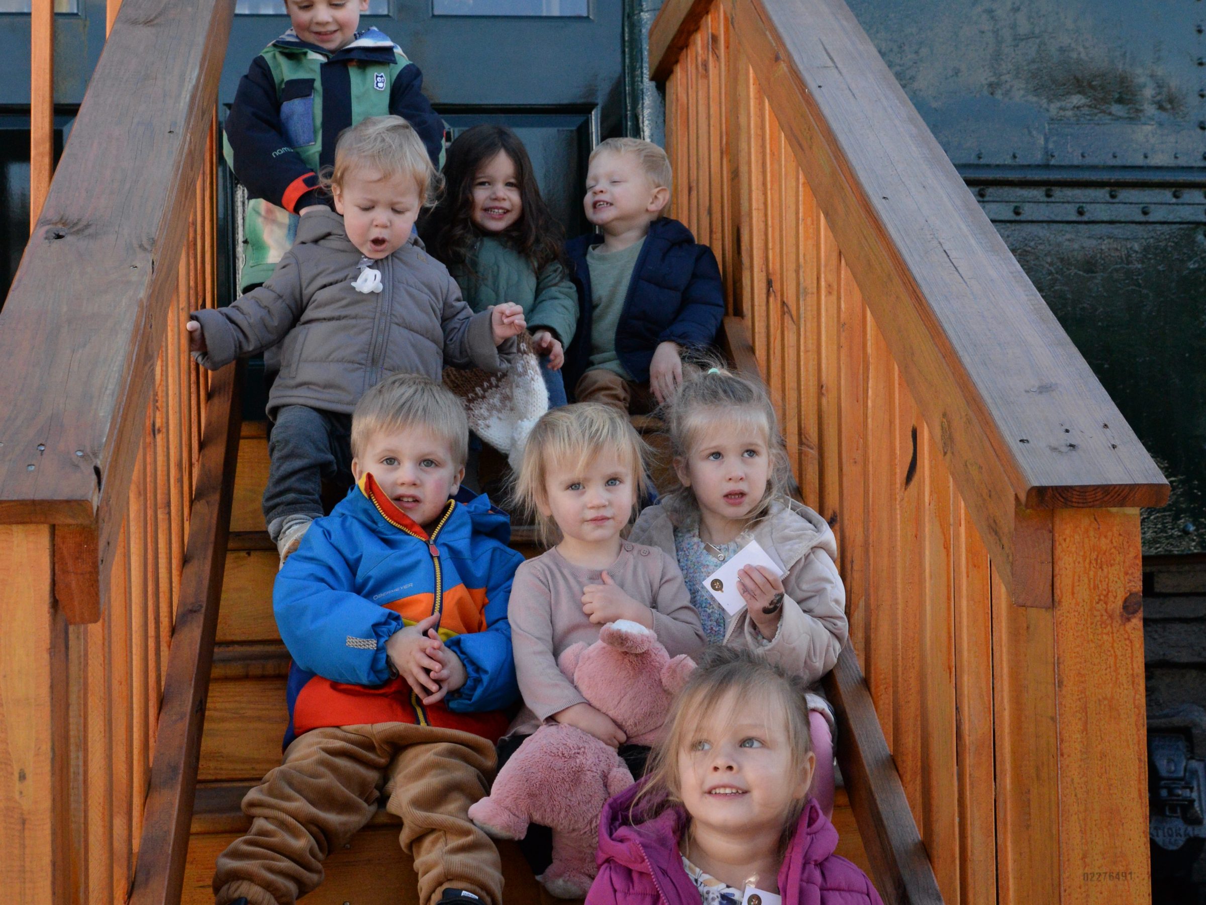 a small child sitting on a wooden bench