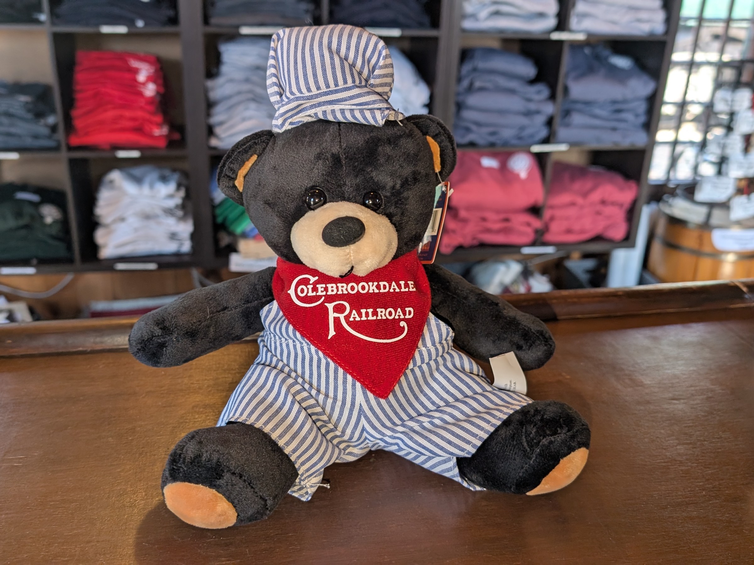 a brown teddy bear sitting on top of a stuffed toy on a table